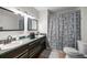 Double vanity bathroom with decorative mirrors, and a shower behind a patterned curtain at 42 Almond Dr, Ocala, FL 34472