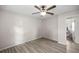 Inviting bedroom featuring neutral walls, wood floors, ceiling fan, and an open doorway to an adjacent room at 42 Almond Dr, Ocala, FL 34472