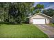 Charming home featuring a well-manicured lawn, attached garage, and stone accents at 42 Almond Dr, Ocala, FL 34472