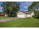 Detached garage with stone accents and a white door is surrounded by a green lawn at 42 Almond Dr, Ocala, FL 34472