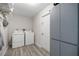 Spacious laundry room with a washer, dryer, built-in shelving, and light-colored wood-look flooring at 42 Almond Dr, Ocala, FL 34472