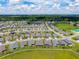 Aerial shot shows neighborhood layout with wide streets, similar house designs, and a spacious green area in the distance at 4419 Nw 54Th Ter, Ocala, FL 34482