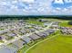 Aerial view of the community's symmetrical home designs and the large green area under a blue sky with scattered clouds at 4419 Nw 54Th Ter, Ocala, FL 34482