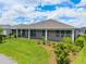 Lush backyard featuring a covered patio, manicured lawn, and vibrant landscaping for outdoor enjoyment at 4419 Nw 54Th Ter, Ocala, FL 34482