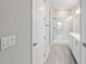 Bright bathroom featuring double sinks, a glass shower door, and wood-look tile flooring at 4419 Nw 54Th Ter, Ocala, FL 34482