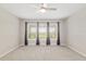 Carpeted bedroom with large windows, gray curtains, and a ceiling fan at 4419 Nw 54Th Ter, Ocala, FL 34482