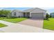 Beautiful home exterior with a well-manicured lawn, brick-paved driveway, and a two-car garage at 4419 Nw 54Th Ter, Ocala, FL 34482