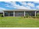 Exterior view of the screened lanai with lush lawn and garden at 4419 Nw 54Th Ter, Ocala, FL 34482