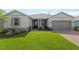 Charming home exterior with lush green lawn, stone accents, and a welcoming front porch at 4419 Nw 54Th Ter, Ocala, FL 34482
