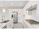 Bright kitchen with white cabinets, stainless steel appliances, cooktop and large island with sink at 4419 Nw 54Th Ter, Ocala, FL 34482