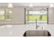 Kitchen counter with stainless steel faucet, sink, and view through sliding glass doors to backyard at 4419 Nw 54Th Ter, Ocala, FL 34482