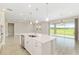 Open kitchen featuring large island with sink, stainless steel dishwasher, and sliding glass doors with a backyard view at 4419 Nw 54Th Ter, Ocala, FL 34482