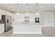 Bright white kitchen boasts a large center island, stainless steel appliances, and stylish pendant lighting at 4419 Nw 54Th Ter, Ocala, FL 34482