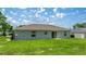 Back exterior view showing a well-maintained yard, and siding details at 458 Marion Oaks Trail Trl, Ocala, FL 34473