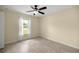 Comfortable bedroom with a ceiling fan, tile floors, and brightly lit window with scenic view at 458 Marion Oaks Trail Trl, Ocala, FL 34473