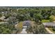 Aerial view of a landscaped property with a modern home surrounded by lush trees, and a long driveway at 5 Larch Course Ter, Ocala, FL 34480