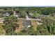Aerial view of a modern home surrounded by lush trees, solar panels on nearby properties, and a long driveway at 5 Larch Course Ter, Ocala, FL 34480