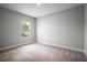 Bedroom with a view of the exterior through the window and neutral colored carpet at 5 Larch Course Ter, Ocala, FL 34480