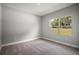 Bedroom with a view of the exterior through the window and neutral colored carpet at 5 Larch Course Ter, Ocala, FL 34480