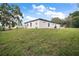 Spacious backyard features an expansive lawn and a modern home exterior with sleek architectural details and dark trim at 5 Larch Course Ter, Ocala, FL 34480