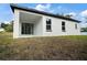 This modern home features a covered outdoor space with sliding glass doors and freshly laid grass at 5 Larch Course Ter, Ocala, FL 34480
