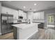 Modern kitchen featuring white cabinets, an island, stainless steel appliances and a tile backsplash at 5 Larch Course Ter, Ocala, FL 34480