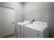 Bright laundry room features a side by side washer and dryer set and convenient white wire shelving for storage at 5 Larch Course Ter, Ocala, FL 34480