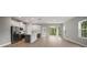 Bright open-plan living area with wood-look floors, a kitchen island, and sliding glass doors at 5 Larch Course Ter, Ocala, FL 34480