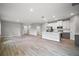 Open-concept living area with wood-look floors, kitchen island, and stainless steel appliances at 5 Larch Course Ter, Ocala, FL 34480
