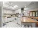 Bright kitchen featuring white appliances, a skylight, and a spacious island at 505 Fairways Ln # B, Ocala, FL 34472
