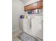 Functional laundry room with cabinets, wire rack, washer and dryer at 505 Fairways Ln # B, Ocala, FL 34472