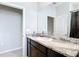 Bright bathroom featuring a granite vanity with dark wood cabinetry and a large mirror at 5233 Nw 43Rd Lane Rd, Ocala, FL 34482