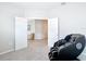 A bedroom with carpet, light grey walls, double doors and a black massage chair at 5233 Nw 43Rd Lane Rd, Ocala, FL 34482