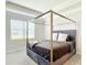 Bright bedroom featuring a canopy bed, window, and neutral walls at 5233 Nw 43Rd Lane Rd, Ocala, FL 34482