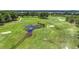 Aerial view of a stunning golf course featuring mature trees, a water feature, and manicured greens at 5233 Nw 43Rd Lane Rd, Ocala, FL 34482