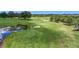 Aerial view of a beautiful golf course with a water feature and meticulously maintained greens and sand traps at 5233 Nw 43Rd Lane Rd, Ocala, FL 34482