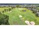 Overhead view of a golf course with homes, mature trees, sand traps, and a water feature at 5233 Nw 43Rd Lane Rd, Ocala, FL 34482