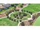 Aerial view showcasing a circular park with pathways, landscaping, and a view of nearby homes and pool at 5233 Nw 43Rd Lane Rd, Ocala, FL 34482