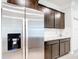 Modern kitchen featuring stainless steel refrigerator and sleek, dark brown cabinetry with granite countertops at 5233 Nw 43Rd Lane Rd, Ocala, FL 34482