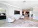 Open-concept living area featuring neutral tones, elegant seating, and a mounted TV, flowing into the kitchen at 5233 Nw 43Rd Lane Rd, Ocala, FL 34482