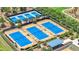 Well-maintained tennis courts with vibrant blue surfaces surrounded by lush landscaping and shaded seating areas at 5233 Nw 43Rd Lane Rd, Ocala, FL 34482