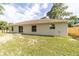 Back exterior view of home featuring sliding glass doors to a manicured backyard at 5596 Nw 57Th St, Ocala, FL 34482