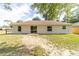 Back exterior view of home featuring sliding glass doors and a well-manicured lawn at 5596 Nw 57Th St, Ocala, FL 34482