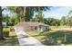 Charming single-story home featuring a well-manicured lawn and a long driveway leading to an attached garage at 5596 Nw 57Th St, Ocala, FL 34482