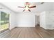 Bright living room with wood-look floors, ceiling fan, and sliding glass doors to the outside at 5596 Nw 57Th St, Ocala, FL 34482