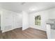 Living room with window and wood-look flooring, leading to the kitchen at 5596 Nw 57Th St, Ocala, FL 34482