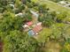 Aerial view of home featuring a private pool, red barn and tree-lined backyard at 581 Ne 44Th Ave, Ocala, FL 34470