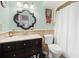 Charming bathroom featuring dark vanity, decorative mirror, and shower at 581 Ne 44Th Ave, Ocala, FL 34470