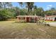 Charming single-story home featuring a red front door, decorative shutters, and lovely landscaping at 581 Ne 44Th Ave, Ocala, FL 34470