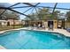 Backyard swimming pool with screened enclosure, lounge chairs, and lush landscaping at 581 Ne 44Th Ave, Ocala, FL 34470
